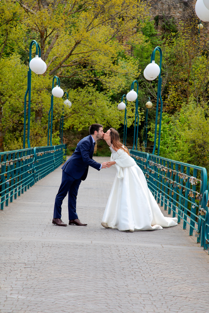 Reportaje de fotos de boda en San Saturio puente novia y novio dandose un beso en el puente de los candados de el río Duero reportaje de boda de Alvaro Rodriguez