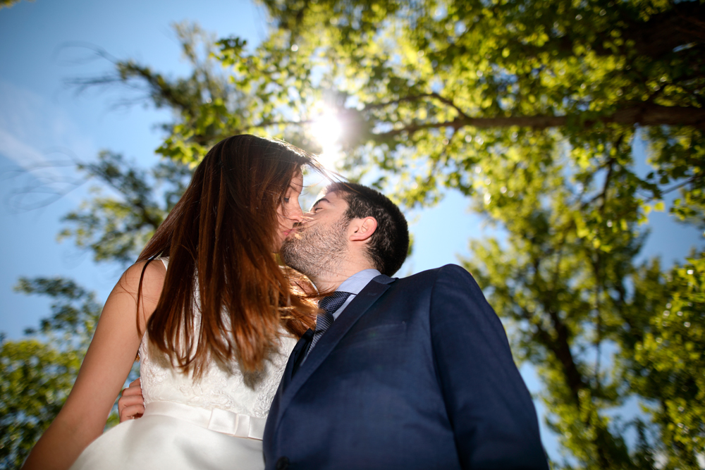 Reportaje de fotos de boda luz artificial beso con disparo de flash en contraluz novios en el rio Duero